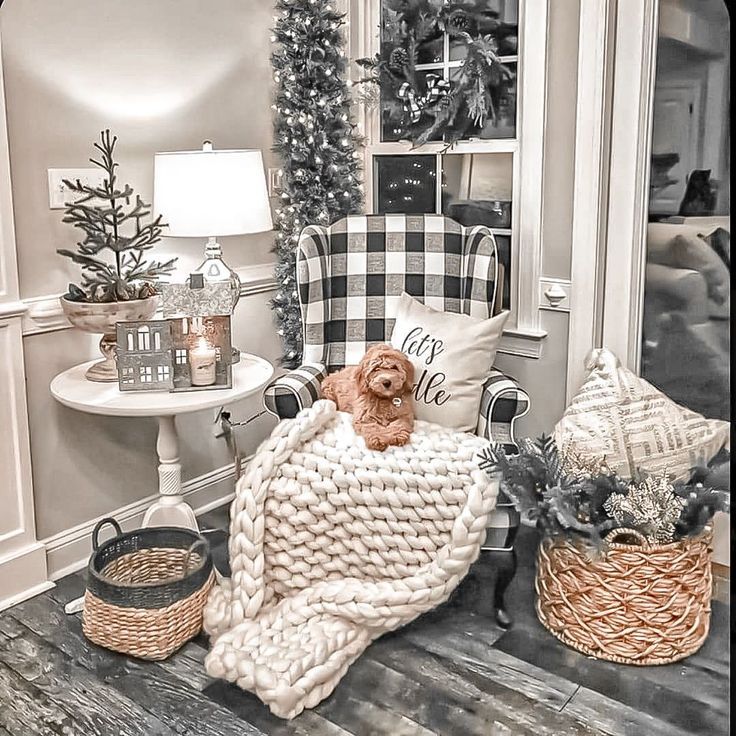 a dog sitting in a chair under a blanket on top of a wooden floor next to christmas trees