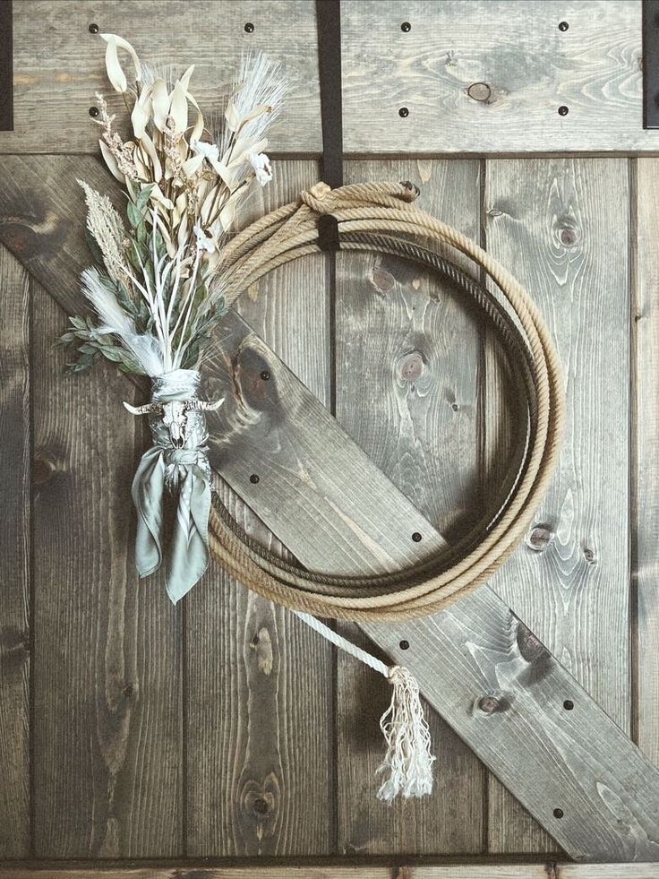 a rope and some flowers sitting on top of a wooden wall