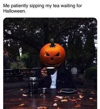 a man in a suit and tie holding a coffee cup with a jack - o'- lantern on it