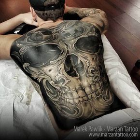 a man laying on top of a bed with a tattoo on his chest and back