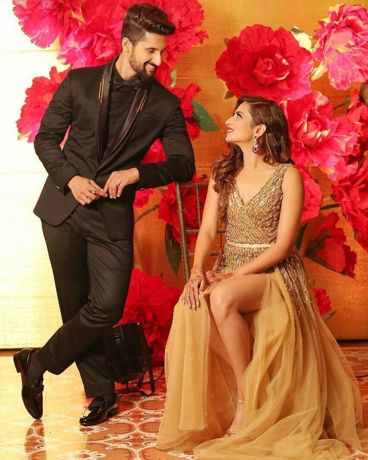 a man in a tuxedo standing next to a woman in a gold dress