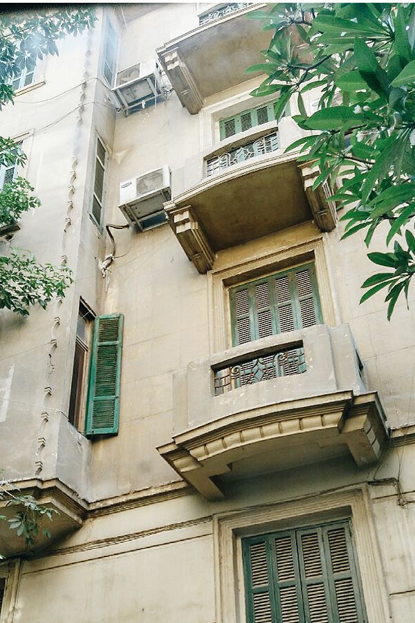 an old building with green shutters and balconies