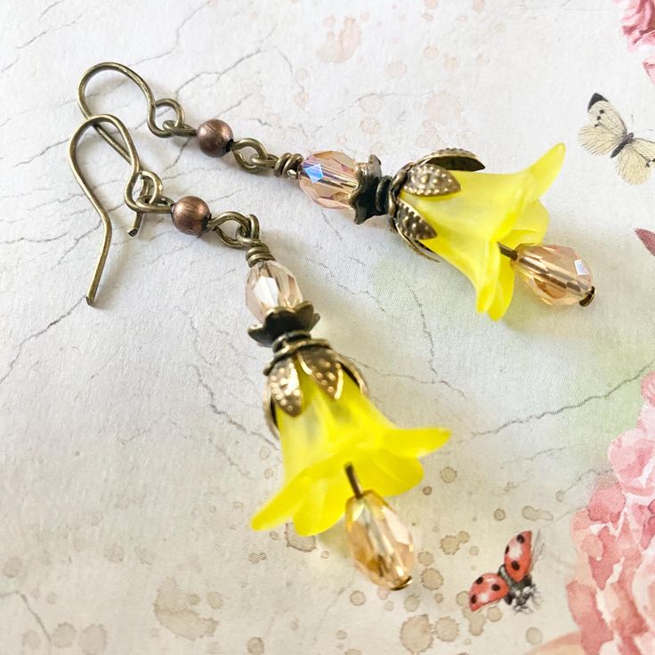 yellow Copper Floral Earrings, Flower Earrings, Bohemian Vintage Dangle Earrings, Fairy Flower Earrings, Yellow Bell Flower Earrings These yellow Copper Floral Earrings are uniquely elegant, flattering and sure to turn heads, they would look stylish for a night on the town and equally great with jeans and a t-shirt. Flirty and feminine, these dangle earrings are as extremely lightweight and make a sweet tinkle sound as they move. They are made of dainty vibrant yellow lucite flowers and sparklin Whimsical Gold Flower-shaped Earrings, Vintage Yellow Flower Earrings, Whimsical Yellow Jewelry With Ear Wire, Gold Whimsical Flower-shaped Earrings, Whimsical Yellow Dangle Earrings, Yellow Whimsical Dangle Earrings, Bohemian Yellow Flower Earrings With Ear Wire, Bohemian Yellow Flower Earrings, Yellow Dangle Flower Earrings For Spring