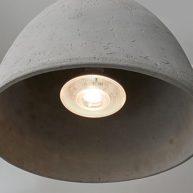 a light that is inside of a cement lamp fixture with a white light in the middle