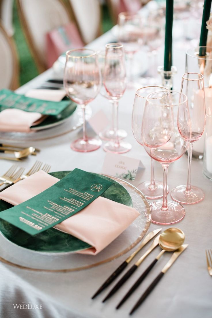 the table is set with wine glasses and place settings