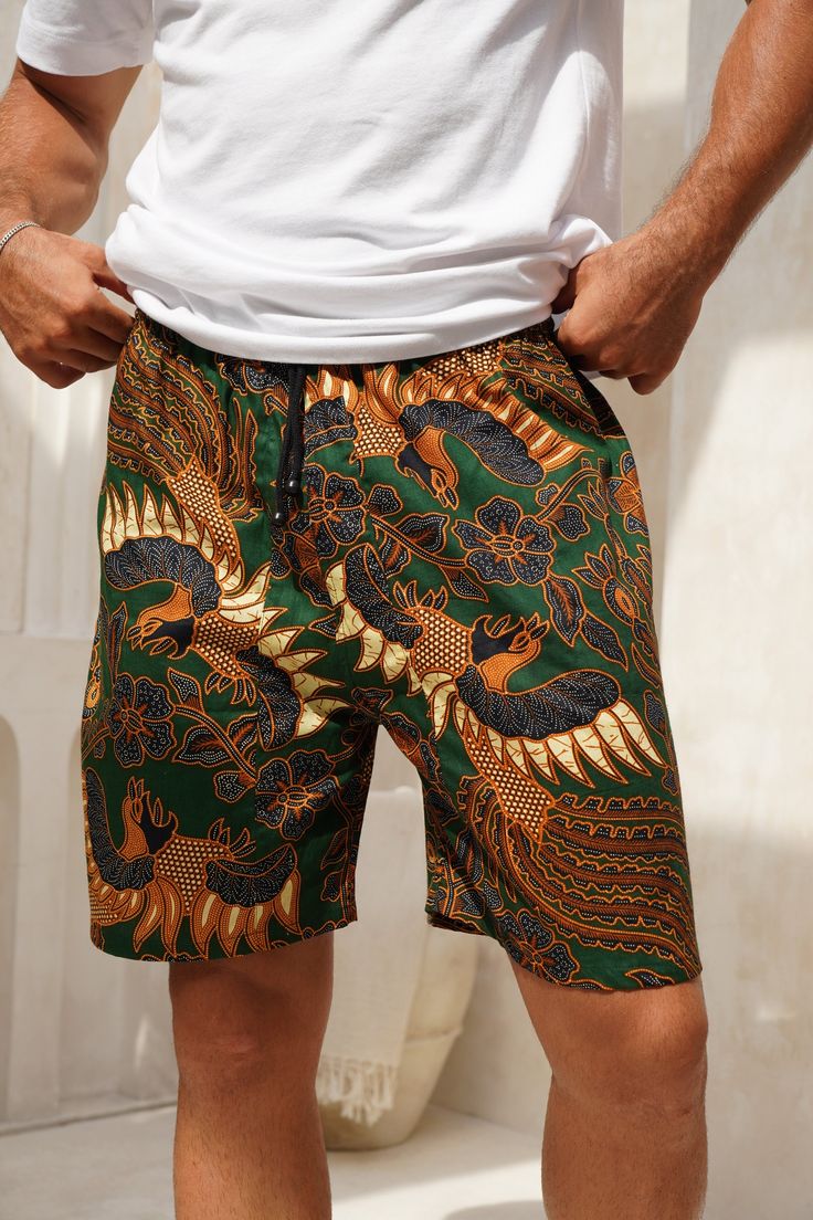 Men's Cotton Batik Drawstring Shorts Available in 5 different colours- Navy, Green, Royal Blue, Red and Red and Black Measurements- Small: Waist - 90cm (stretched out) , 55cm (not stretched) Length - 100cm Medium: Waist - 95cm (stretched out), 60cm (not stretched) Length - 103cm Large: Waist - 100cm (stretched out), 65cm (not stretched) Length - 105cm XL: Waist - 105cm (stretched out), 70cm (not stretched) Length - 107cm What you need to know: - Elasticated waistband - very stretchy, lots to give  - Drawstring tie - Pockets - Loose fit  - Made from Cotton  - Batik is made by hand using wax so there may be some imperfect ink dye marks - 5% of profits go to charity For wholesale orders you can simply and easily buy from our Faire link- weartheworld.faire.com As a thank you to all my amazing Multicolor Hawaiian Short Bottoms, Multicolor Hawaiian-style Shorts, Multicolor Hawaiian Style Shorts, Tropical Cotton Shorts For Beach, Green Hawaiian Style Shorts For Vacation, Green Hawaiian Shorts For Vacation, Green Hawaiian Style Short Bottoms, Casual Cotton Swimwear For Festivals, Multicolor Bermuda Shorts For Beach