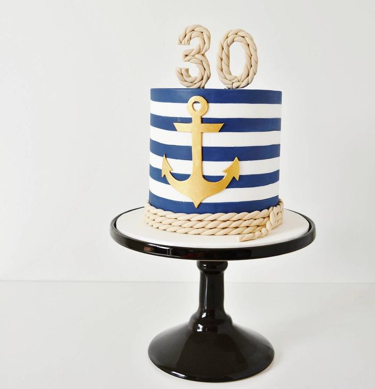 there is a blue and white cake with an anchor on the top that says 30