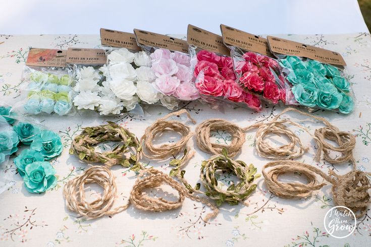 there are many different colors of flowers on this table cloth, and each one is tied with twine