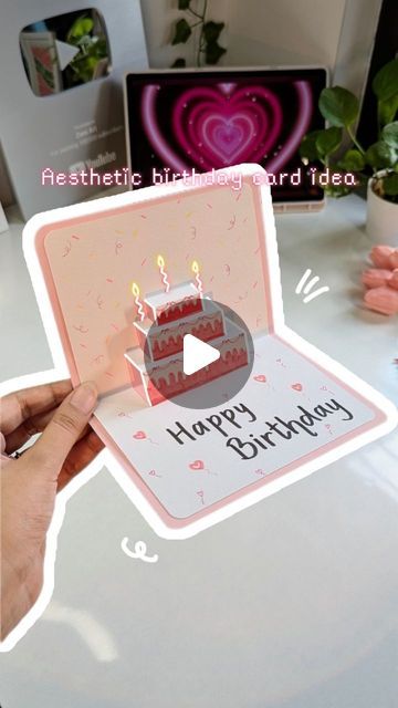 someone holding up a card with a birthday cake on it and the words happy birthday