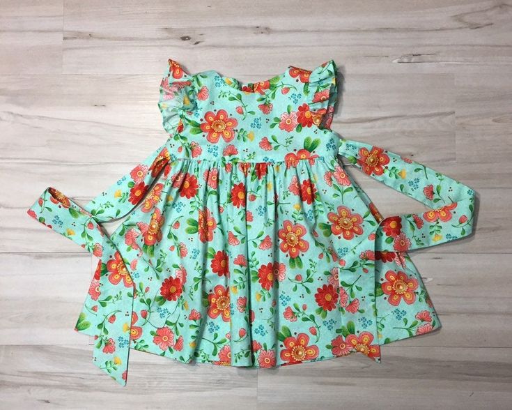 "Beautiful handmade baby girl, toddler, Girl dress is a Retro style , flutter sleeve, custom dress made from a Bright floral cotton fabric. The dress buttons in the back, it also ties in the back. All seams are finished. Sewn with great care. Boutique quality sewing. I have a size 4 ready to ship. If you need the length of the dress to be different please include a message with order. Measurements of the dress. size , length, 3 months length 12.5\". 6 months, length 14.5\". Size, Chest, Waist, L Playful Floral Print Dress With Flutter Sleeves, Playful Floral Print Dress With Ruffle Sleeves, Playful Ruffle Sleeve Dress With Floral Print, Flowy Spring Twirl Dress With Flutter Sleeves, Cute Flowy Twirl Dress With Flutter Sleeves, Spring Multicolor Twirl Dress With Flutter Sleeves, Cute Flowy Dresses With Flutter Sleeves, Spring Flutter Sleeve Twirl Dress For Garden Party, Fitted Flutter Sleeve Twirl Dress For Spring