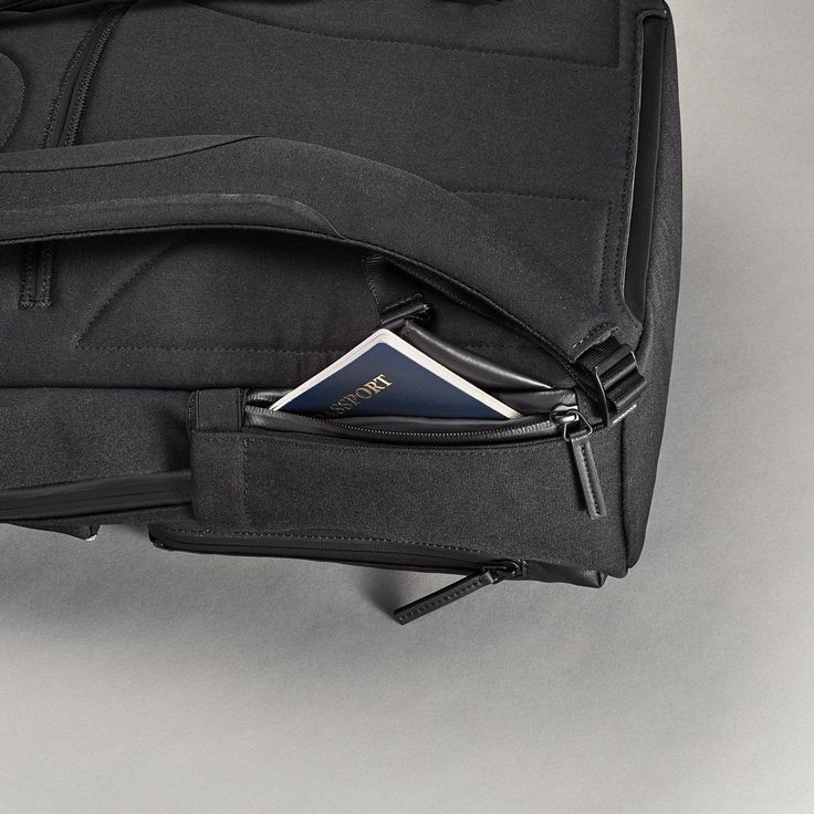 a piece of luggage with a passport in it's pocket on a gray surface