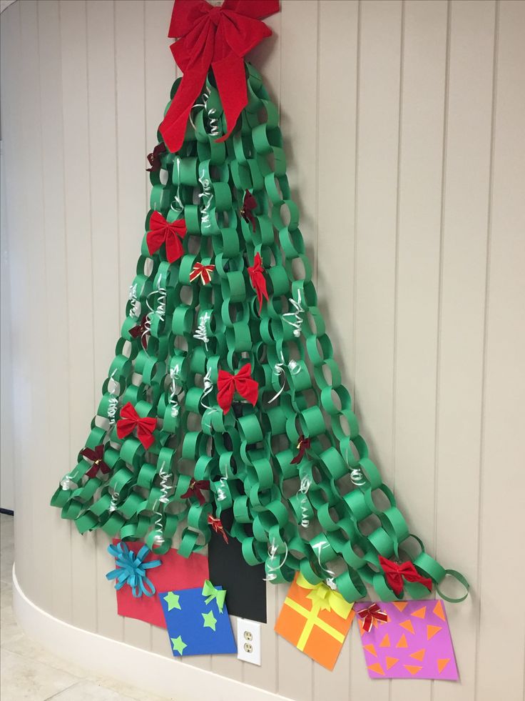 a christmas tree made out of green wrapping paper with red bows and ribbons on it