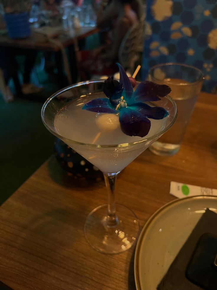 a glass filled with liquid sitting on top of a wooden table