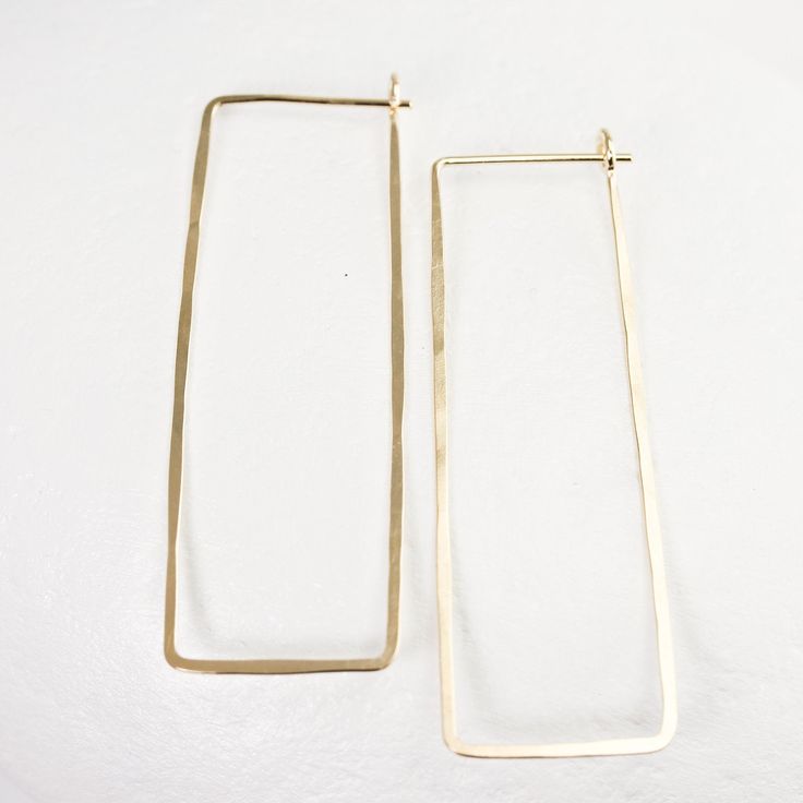 "These long solid gold rectangle hoops have been hammered for strength and for a lovely, subtle texture. They're made from recycled 14K, which can withstand daily wear with ease. I also offer a platinum option. The posts tuck into a loop catch on the backside of the earring and don't require backs. This particular pair of earrings from the line is a long rectangle - between 1 7/8 and 2 inches long and about 5/8\" wide. Please note that the white gold contains nickel. Shop home: http://www.lotuss Modern Hammered Rectangular Earrings, Minimalist Hammered Rectangular Earrings, Hand Forged Rectangular Gold Jewelry, Everyday Hammered Rectangular Jewelry, Minimalist 14k Gold Rectangular Hoop Earrings, Herkimer Diamond Necklace, Hammered Hoop Earrings, Rectangle Earrings, Stacked Bangles