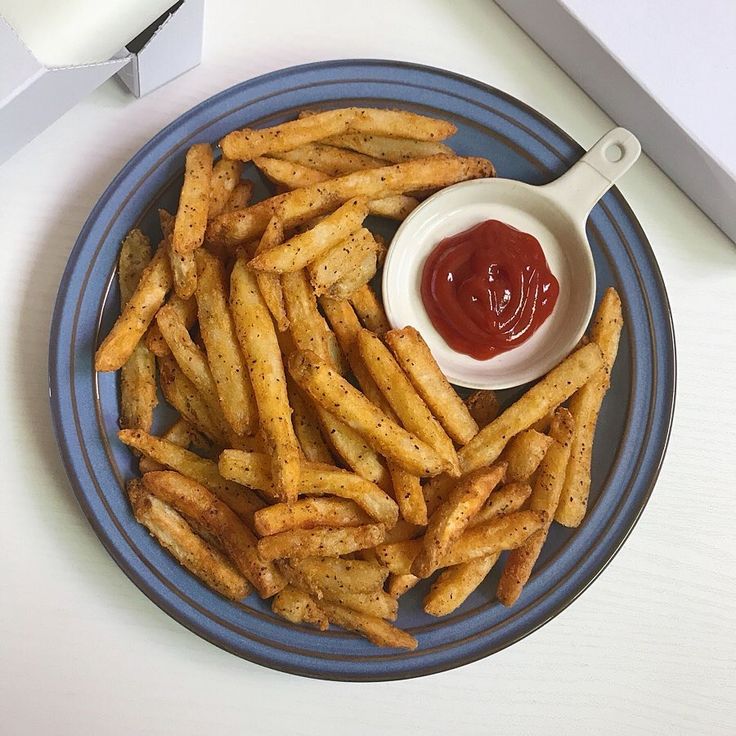 french fries with ketchup on a blue plate