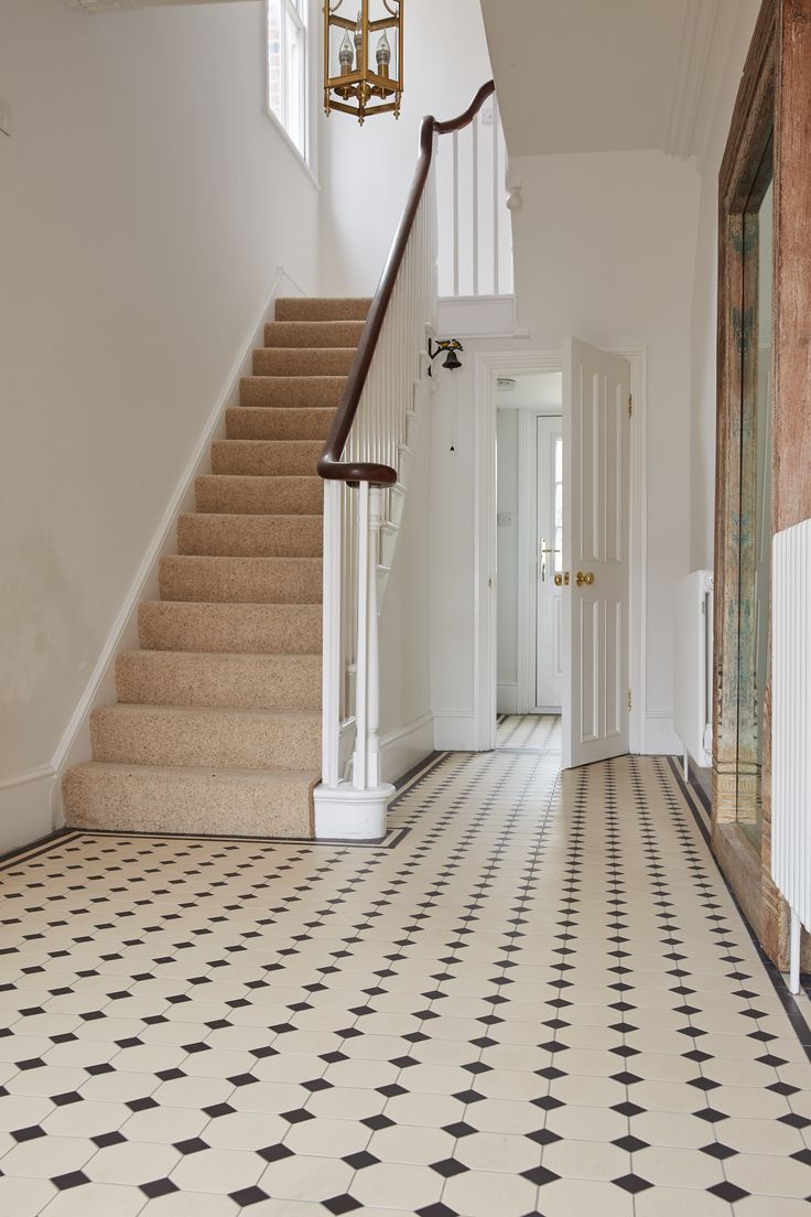 an entryway with stairs and tiled flooring