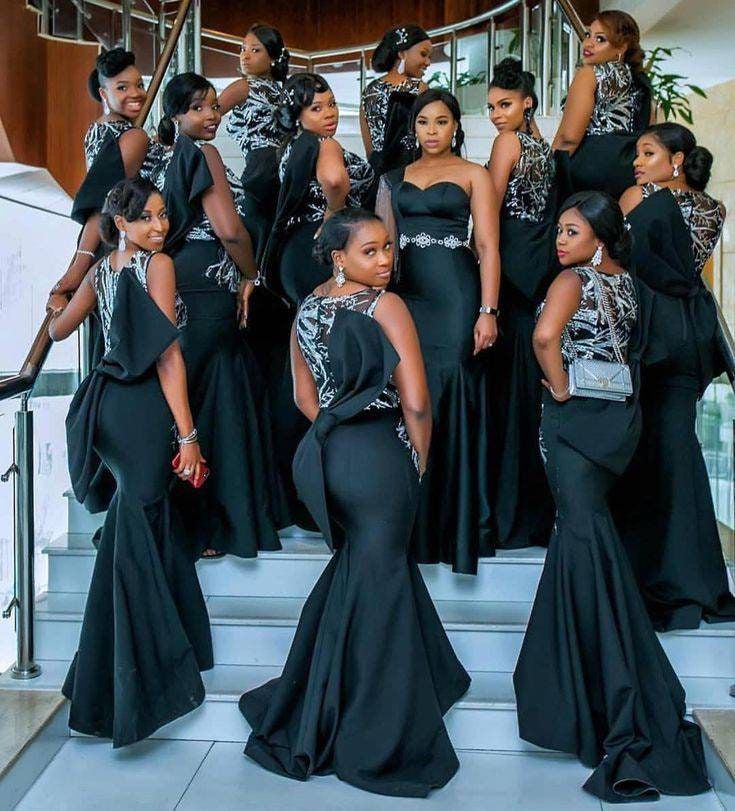 a group of women in black dresses standing on stairs