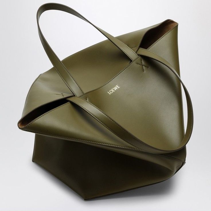 Ever seen a tote that makes you second-guess reality with its stunning geometric design? This beautiful olive green piece is crafted from the finest leather and adds a touch of minimalist elegance to your everyday look. It's like having a piece of art that's both practical and stylish. Geometric design Two top handles Small front logo Made in Spain 100% Leather Color: Beige (Code: 8795) Size: One Size Season: FW24 Department: Men Family: Totes Section: Bags Loewe Puzzle, Men Cream, Bottega Veneta Shoulder Bag, Large Bag, Green Leather, Leather Tote Bag, Geometric Design, Leather Tote, Calf Leather