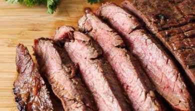 sliced steak on a cutting board with parsley