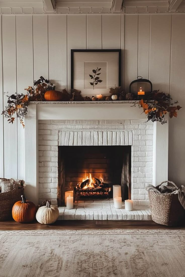 a fireplace with candles, pumpkins and other decorations on it in a living room