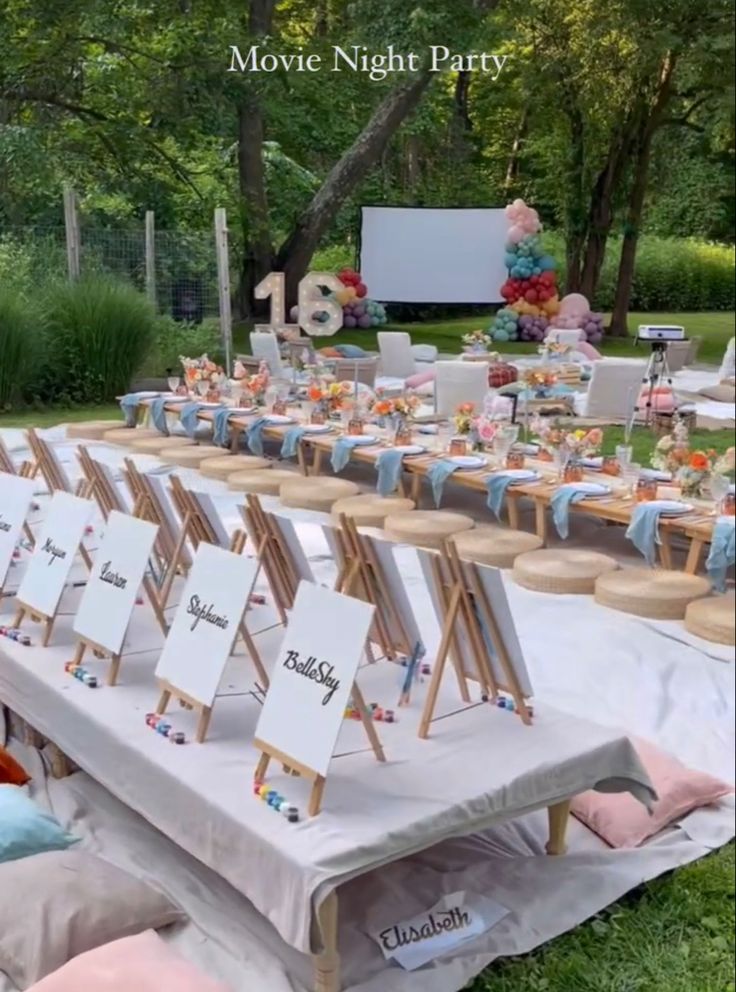 an outdoor movie night party with tables and chairs