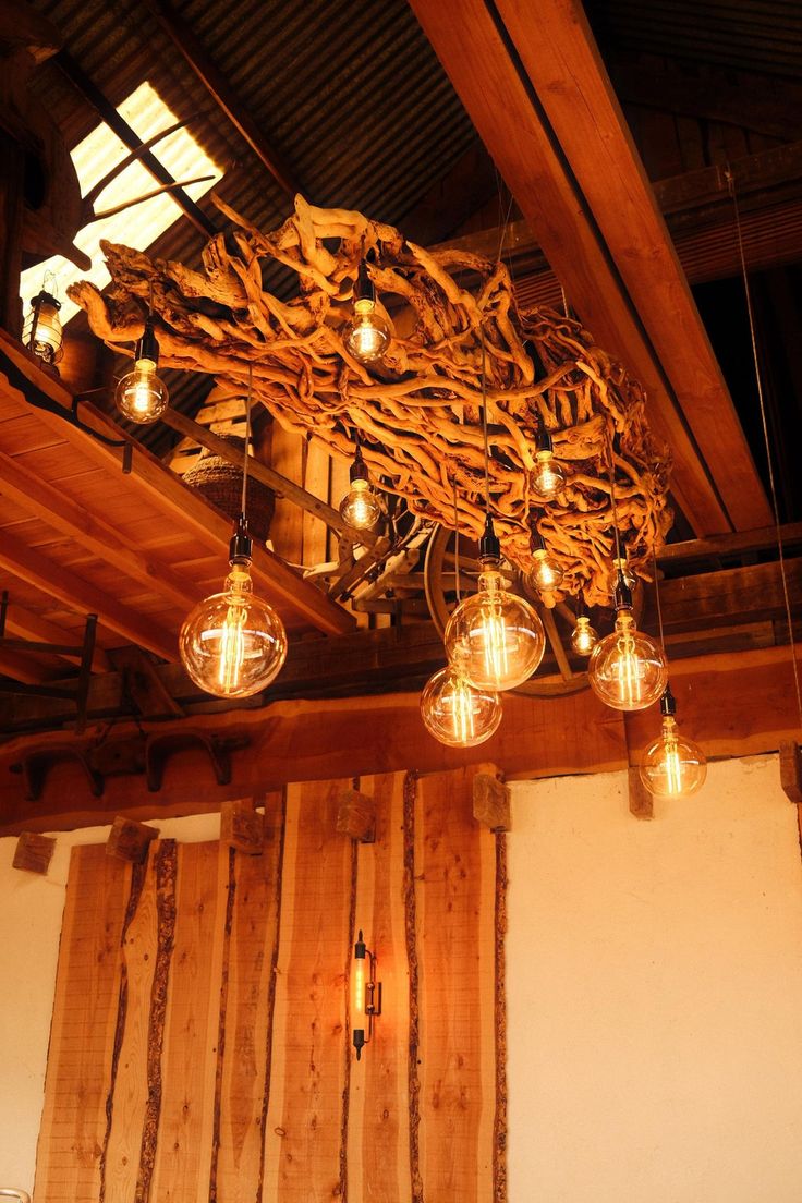 some light bulbs hanging from the ceiling in a room with wood paneling and beams