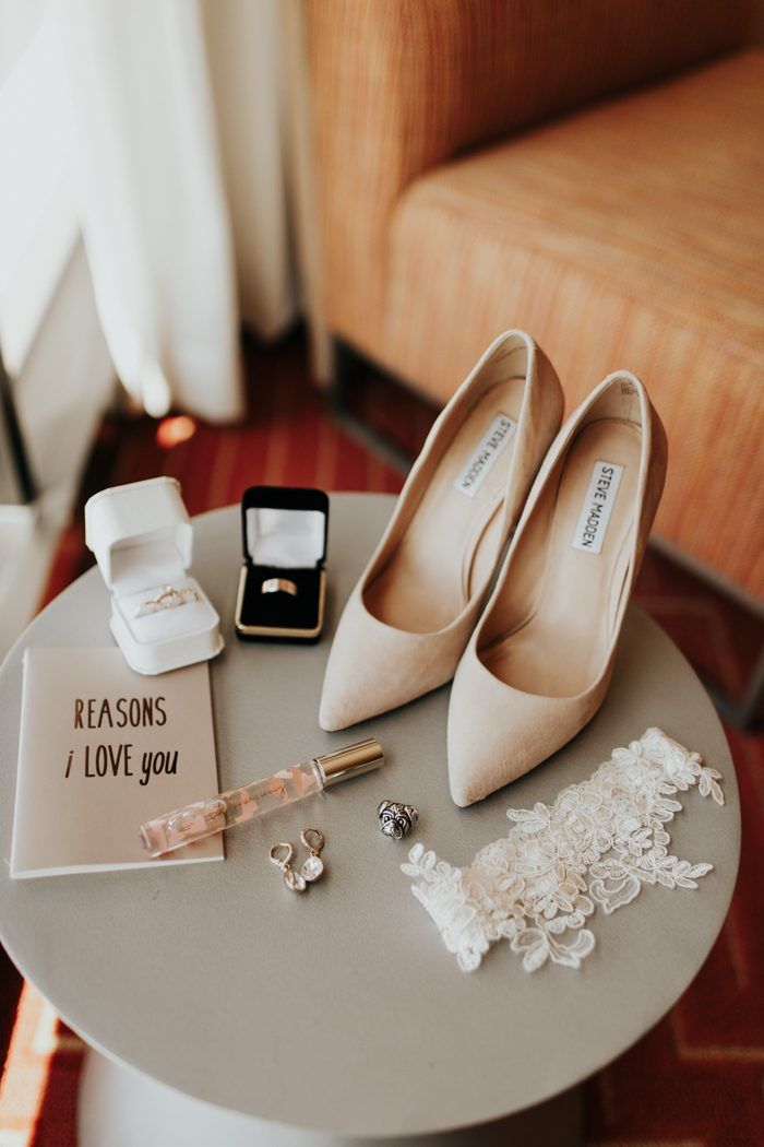 wedding shoes and jewelry on a table in front of a chair with a sign that says reason i love you