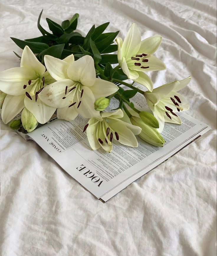 A bouquet of what lillies is sitting on a vogue magazine in a white sheet. White Lilies Aesthetic, White Lily Flower Aesthetic, Flowers Widget, Stargazer Bouquet, Editorial Photoshoot Ideas, Pilates Mom, Narcissa Black, Aesthetic Editorial, Editorial Vogue