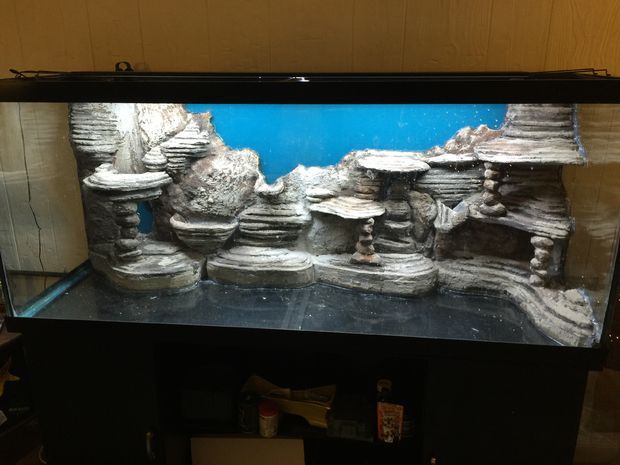 an aquarium is shown with rocks and water in the bottom right hand corner, on top of a black cabinet