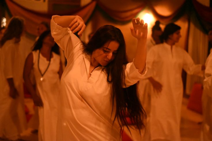 a group of women in white dresses dancing