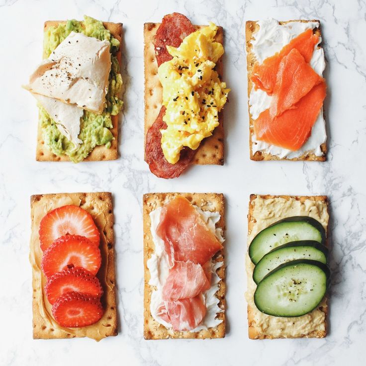 several different types of food on crackers with cucumbers