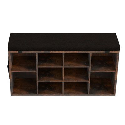 a large wooden shelf with many compartments on the top and bottom, along with a black cushion