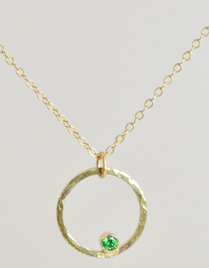 "Minimal Rustic Necklace with a flash of sparkle & color. We completely fabricate the pendant in our studio. The 14k gold filled circle is hammered for interest. The 3mm Emerald is tube set and nestled inside the circle. You can choose to add up to two more birthstones to this pendant for the perfect gift for mom, sister, aunt, grandma. Necklace: Hammered 14k Gold filled Circle with Emerald CZ Birthstone - High quality 14k Gold filled Chain made to your size 16-20\". - Perfect on its own or 14k Gold Filled Round Birthstone Necklaces, 14k Gold-filled Round Birthstone Necklaces, Round Birthstone Necklaces In 14k Gold Filled, Gold Bezel Setting May Birthstone Necklace, 14k Gold-filled Round Birthstone Necklace, Gold Round Birthstone Jewelry, Round 14k Gold Emerald Birthstone Necklace, Recycled Gold Round Birthstone Necklaces, Green Birthstone Jewelry In Recycled Gold