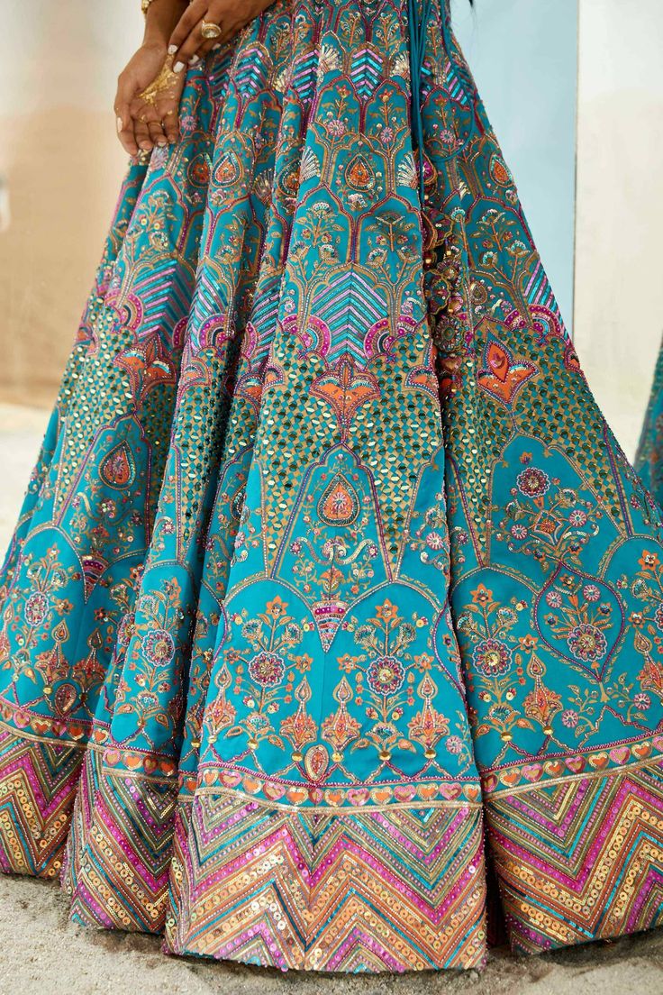 The erum lehenga set in blue shade with multicolored print highlighted with embroidery and mirror is a complete show stopper. The bralette has floral motifs decorated with mirror and beads. A total show stealer that compiles the vibe of multi-generation and accentuates the personality of the wearer. Bollywood Style Multicolor Sharara With Intricate Embroidery, Bollywood Style Multicolor Sets With Intricate Embroidery, Designer Multicolor Lehenga With Zari Work, Designer Anarkali Set With Multicolor Intricate Embroidery, Designer Multicolor Anarkali Set With Intricate Embroidery, Designer Multicolor Lehenga With Intricate Embroidery, Multicolor Embroidered Lehenga For Designer Wear, Multicolor Lehenga With Intricate Embroidery For Festive Occasions, Designer Multicolor Embroidered Lehenga