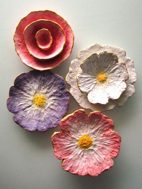 three flower shaped dishes sitting next to each other