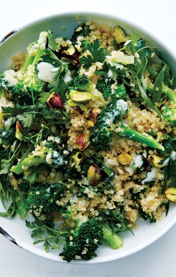 a white bowl filled with broccoli and other vegetables on top of a table