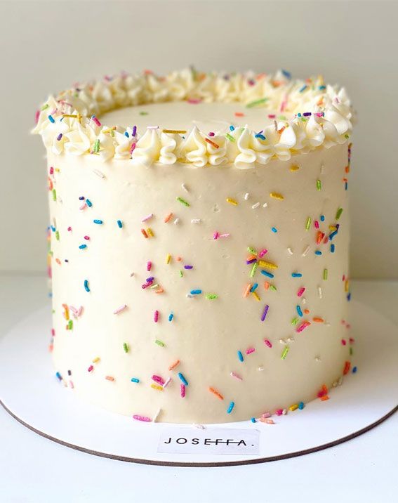 a cake with white frosting and sprinkles