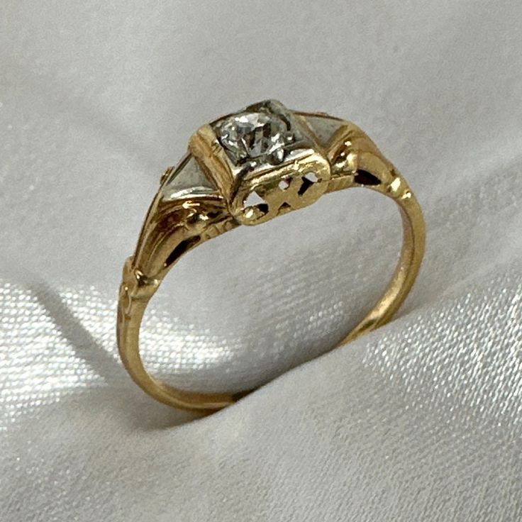 a diamond ring sitting on top of a white cloth