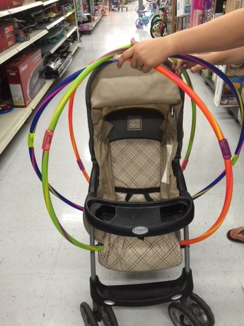 a person pushing a stroller in a store with rings on the handlebars