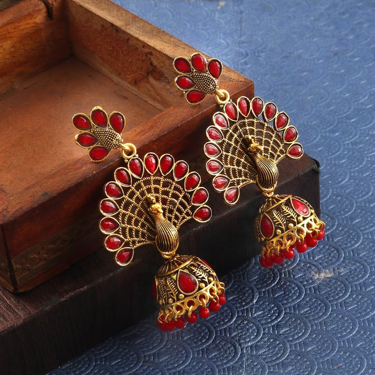 Overview These stylish Jhumki Earrings set from JewelryTrack will certainly leave you spellbound. These Jhumki Earrings set have an excellent finish and gives out an exquisite sense of style. If you are looking for an amazing Fashion Jewelry set for special occasions such as Anniversary, Engagement, Party, Wedding or for gifting , then your search ends here. Item Description: The look is stunning and preciously suitable for all kinds of dressy occasions. Metal: Brass OCCASION: PARTY WEAR , WEDDI Red Earrings For Puja And Festivals, Peacock Design Jhumkas For Navratri Puja, Navratri Peacock Design Jhumkas For Puja, Navratri Puja Peacock Design Jhumkas, Red Temple Jewelry Earrings For Navratri, Peacock Design Earrings For Puja Festivals, Festival Peacock Design Earrings For Puja, Red Earrings For Puja And Diwali, Red Meenakari Earrings For Puja