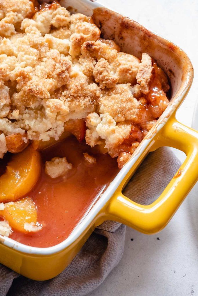 a casserole dish with peaches and crumbled topping