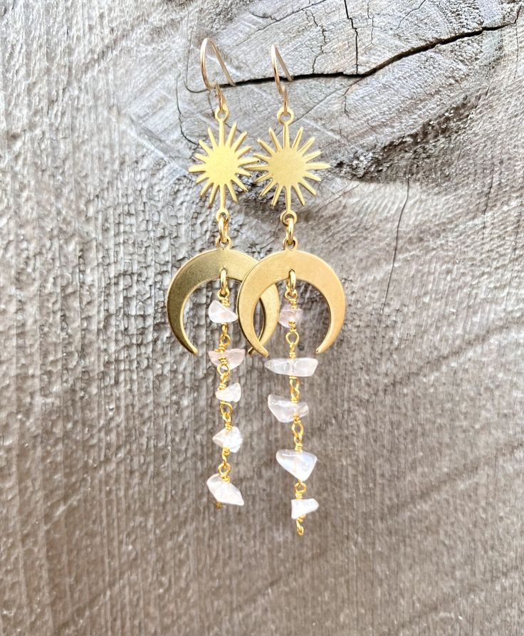 🌙Gorgeous dainty crystal dangle earrings with a little boho witchy twist of moon and/or sun charm. All natural raw chip crystals in unique shape in beautiful colors that will compliment any outfits and turn heads. ☀️Simple, Dainty, Delicate, Elegant and Romantic. The picture does not do its justice the piece is so much prettier in person. Perfect for birthday, Christmas, mother's day, bridesmaid gifts, anniversary, and any holidays. Silver plated Gold plated Sterling Silver 14k Gold filled Draw Moonstone Dangle Jewelry With Moon Charm, Crescent Wire Wrapped Earrings For Gift, Gold Moon Shaped Wire Wrapped Earrings, Crescent Wire Wrapped Earrings As Gift, Mystical Moon Charm Dangle Earrings, Moon Shaped Wire Wrapped Earrings Gift, Celestial Moon Charm Dangle Crystal Earrings, Celestial Wire Wrapped Dangle Earrings, Celestial Gemstone Drop Earrings