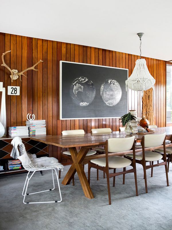 a dining room with wood paneling and white chairs