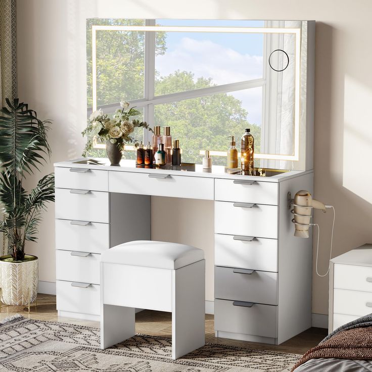 a bedroom with a vanity and stool next to a large window overlooking the trees outside