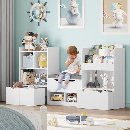 a young child sitting on top of a book shelf in a room with blue walls