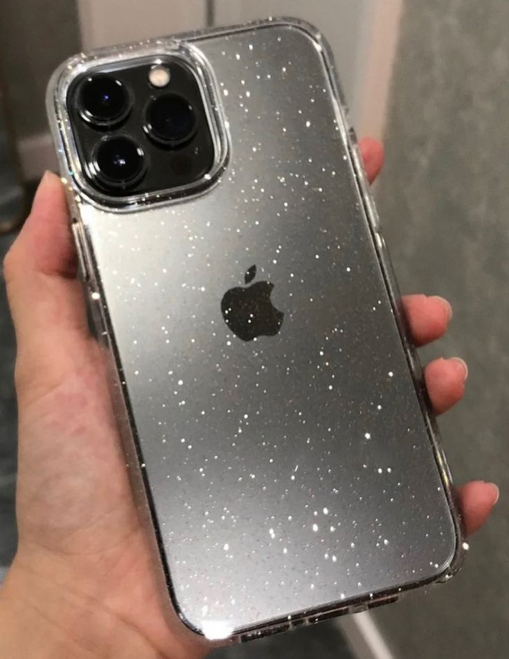 a person holding an iphone in their hand with glitter on the back and side of it