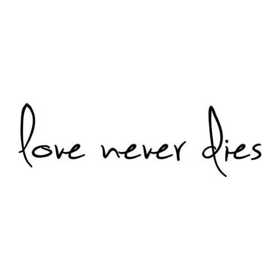 the words love never dies written in black ink