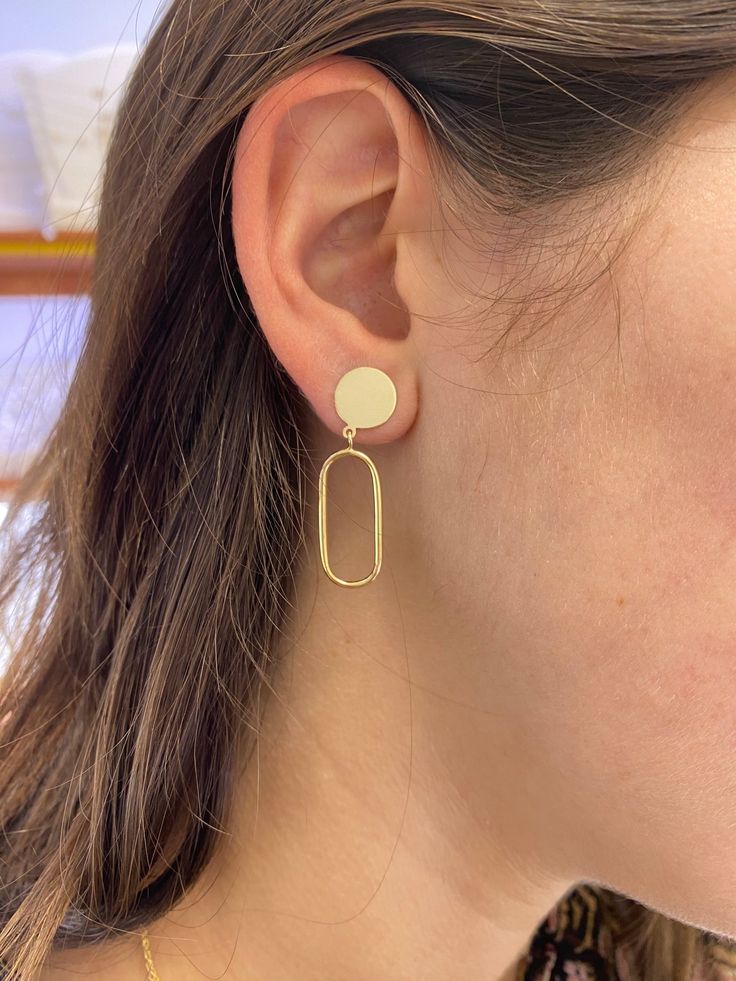 These Circle Paper Clip Dangle Earrings add a touch of class and modern style to your daily look. Made with 14 karat gold, the lightweight design and high polish make them perfect for everyday wear and to elevate your workplace attire. A must-have accessory for the fashion-forward individual! Details: Metal: Solid and Semi-Solid (Hollow) 14 karat gold Dimensions: Length: 1.5" Inch by 0.30" Wide, the circle is solid gold 10.0mm in diameter and the Oval Open Dangle (Hollow) 22.0mm (L) X 10.0mm (W) Minimalist Gold-plated Earrings With Polished Finish, Minimalist Gold Plated Earrings With Polished Finish, Simple Design 14k Gold Earrings, Modern Round Linear Earrings For Formal Occasions, Modern Linear Round Earrings For Formal Occasions, Modern White Gold Earrings With Shiny Finish, Trendy Yellow Gold Earrings For Formal Occasions, Modern White Gold Earrings, Minimalist Shiny Finish Earrings For Gift