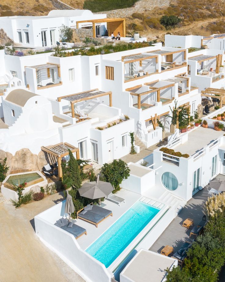 an aerial view of a white house with a pool