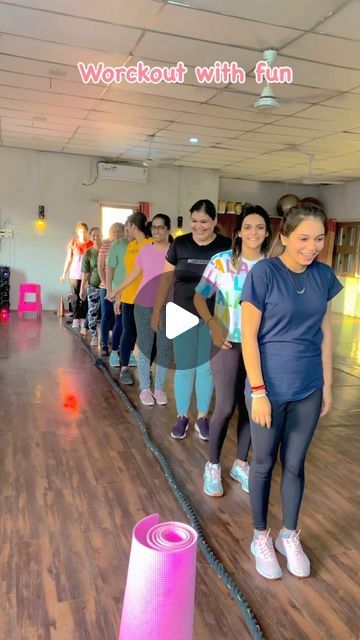 a group of people standing on top of a wooden floor next to a pink tube